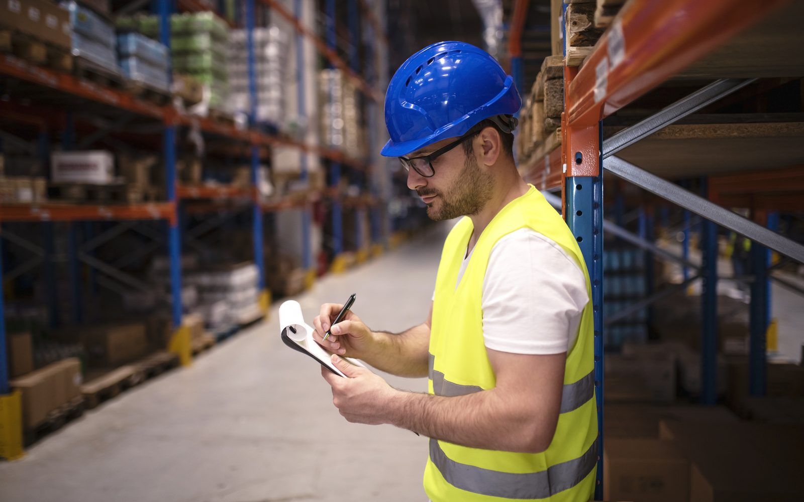 Storekeeper checking material stock against a job list in a warehouse